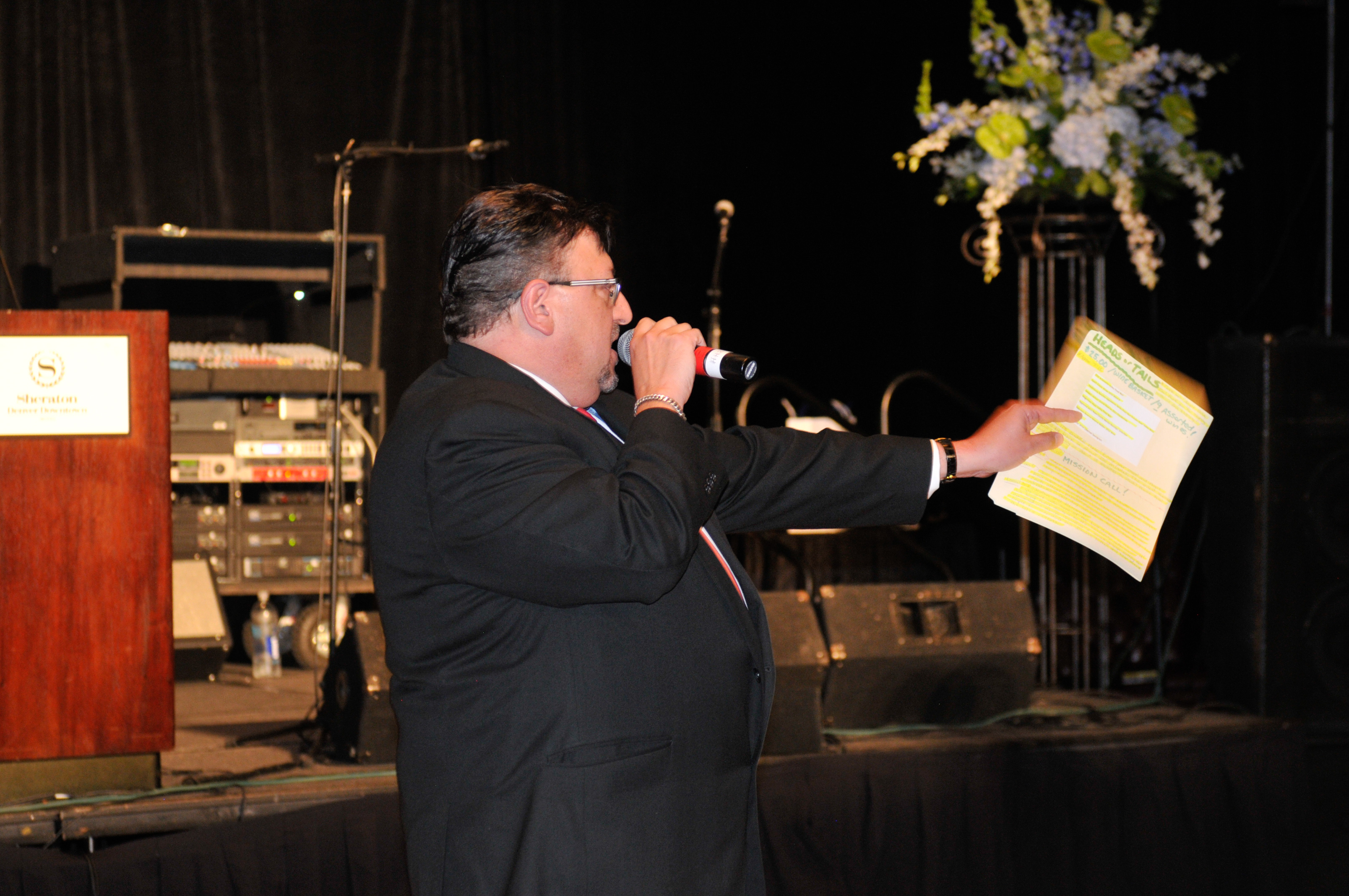 Auctioneer Jim Belz starts out the "Heads or Tails" game